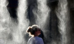 Une femme se rafraîchit sous un brumisateur lors de la Fête de la Musique à Bordeaux, le 21 juin 2026