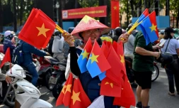 Une vendeuse de drapeaux vietnamiens et de l'armée Viet Cong, le 29 avril 2025 à Ho Chi Minh Ville