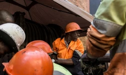 Des techniciens se lavent les mains après avoir posé des câbles électriques dans un tunnel sous Johannesburg, le 8 septembre 2017