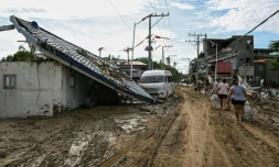 Les habitants marchent le long d'une rue couverte de boue aprĂšs le passage du typhon Kalmaegi Ă Liloan, dans la province de Cebu aux Philippines, le 6 novembre 2025