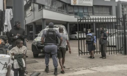 Un policier sud-africain interpelle un ressortissant étranger soupçonné d’être en situation irrégulière lors d’une opération de contrôle et de fouille dans le centre de Durban, le 29 juin 2026