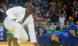 Teddy Riner (blanc) face à l'Algérien Mohammed Amine Tayeb (bleu) lors des qualifications pour les quarts au tournoi olympique de judo, le 12 août 2016 à Rio