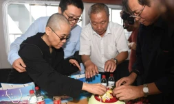 Liu Xia, veuve du prix Nobel de la paix Liu Xiaobo, prépare des fleurs avant que les cendres de son époux ne soient dispersées en mer, le 15 juillet 2017 au large de Dalian eb Chine. Photographie fournie par le service de presse de Shenyang