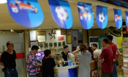 Des parieurs dans une boutique de loto sportif à Shanghai, le 2 juillet 2018