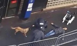 Une capture d'écran d'une vidéo obtenue par l'AFP montre la police et un robot démineur autour du cadavre d'un homme abattu par la police devant le commissariat de la Goutte-d'Or à Paris, le 7 janvier 2016