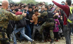 La police macédonienne tente de contenir le 18 octobre 2015 une foule de migrants au poste-frontière de Gevgelija, entre la Macédoine et la Grèce 