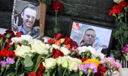 Des photos de l'opposant Alexeï Navalny sont exposées prÚs de fleurs déposées au niveau du monument pour les victimes des répressions politiques, le 17 février 2024 à Moscou