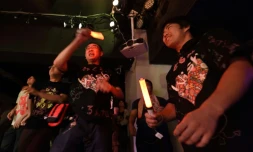 Des adultes assistent au spectacle d'un groupe de chanteuses "idoles", des fillettes se produisant sur scène, le 29 juillet 2017 dans un club à Tokyo