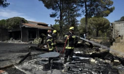 Un pompier arrose les décombres d'une maison détruite par un incendie, le 15 août 2023 à Saint-André, prÚs d'ArgelÚs-sur-Mer, dans les Pyrénées-Orientales