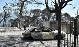 Des habitants parcourent le zone dévastée par les flammes de l'ancien Club Mediterranée à Lambiri, à l'est de Patras dans le Péloponnèse en Grèce, le 1er août 2021