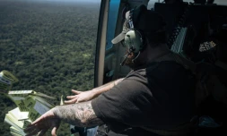 L'Américain Caleb Weiss, employé de la fondation américaine Bridgeway, lance des tracts depuis un hélicoptÚre sur les bastions des ADF, les exhortant à se rendre, le 8 mai 2024 au-dessus du territoire de Beni, dans la province du Nord-Kivu, dans l'est de la RDC