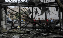 Des piétons passent devant des débris près d'une station de métro après une attaque russe à Kiev, le 21 juillet en Ukraine