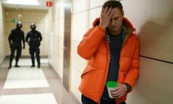 L'opposant russe Alexeï Navalny et deux policiers en arrière-plan, dans un couloir d'un centre d'affaires qui héberge son organisation anti-corruption, le 26 décembre 2019 à Moscou
