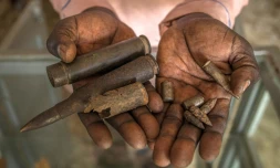 Un homme montre des balles exposées au Mémorial de Lukodi, souvenir du'un massacre perpétré dans ce village du nord de l'Ouganda en mai 2004 par la guérilla ougandaise de l'Armée de résistance du Seigneur (LRA), le 4 septembre 2025