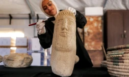 Une membre de l'association Mayasem pour la culture et les arts nettoie un artefact à la brosse, sous une tente à Khan Younès, dans le sud de la bande de Gaza, le 11 juillet 2026