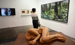 Une femme regarde des oeuvres exposées à la foire Art Basel à Hong Kong, le 23 mars 2023
