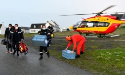 Des soignants du Service départemental d'incendie et de secours arrivent en hélicoptÚre avec deux caisses contenant des vaccins anti-Covid-19 sur l'ßle de Hoëdic (Morbihan), le 29 janvier 2021