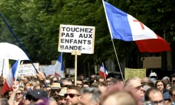 Un manifestant tient une banderole sur laquelle on peut lire "Ne touchez pas aux enfants" lors d'une journée nationale de protestation contre le vaccin obligatoire contre le Covid-19 pour certains travailleurs et l'utilisation obligatoire du pass sanitaire à Lille, dans le nord de la France, le 21 août 2021