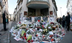 Des fleurs et des bougies sont déposées devant les locaux de Charlie Hebdo à Paris en hommage aux victimes de l'attentat, le 11 janvier 2015