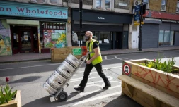 Un homme livre de la biÚre dans un pub de Londres en prévision de l'allÚgement des restrictions sanitaires le 9 avril 2021