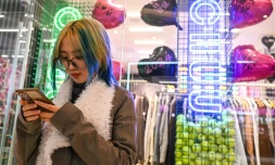 Wang Xiuting discute sur son téléphone avec son petit ami virtuel Wantalk, un chatbot à intelligence artificielle créé par la société technologique chinoise Baidu, dans un centre commercial de Pékin, le 2 février 2024