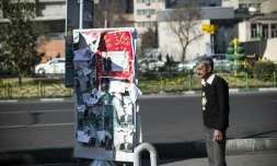Un homme se tient à cÎté d'affiches électorales à Téhéran, capitale de l'Iran, le 25 février 2016