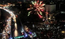 Vue aérienne de feux d'artifice et de la foule de Syriens célébrant le renversement du président Bachar al-Assad, sur la place des Omeyyades à Damas, le 13 décembre 2024