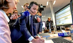 Le ministre des Comptes publics Gérald Darmanin parle avec un contribuable au téléphone depuis le centre des impÎts d'Amiens, le 2 janvier 2019