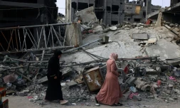 Une femme passe devant les décombres d'un immeuble à Rafah, dans le sud de la bande de Gaza, soumis aux bombardements israéliens, le 28 octobre 2023