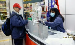 Une caissière portant un masque de protection dans un supermarché à Barcelone le 29 mars 2020