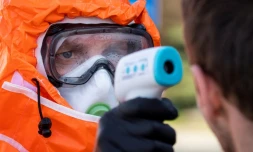 Un fonctionnaire polonais vérifie la température de Polonais qui franchissent la frontière, en direction de leur pays natal, à Francfort-sur-Oder, le 16 mars 2020