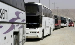 Des bus affrétés par le régime syrien attendent des rebelles ayant accepté de quitter la localité de Harasta dans la Ghouta orientale, prÚs de Damas, le 22 mars 2018