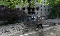 Une femme passe devant un immeuble bobardé à Siversk, dans la région de Donetsk, le 23 juin 2022
