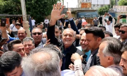 Le candidat réformateur pour la présidentielle iranienne, Massoud Pezeshkian (C), le 5 juillet 2024 au milieu de partisans devant un bureau de vote à Téhéran