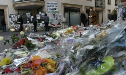Des personne rendent hommage au victime de l'attentat contre l'hebdomadaire Charlie Hebdo au siÚge du journal, le 15 février 2015