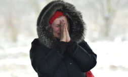 Une femme attend ses proches qui traversent un pont détruit pour évacuer la ville d'Irpin en Ukraine le 8 mars 2022