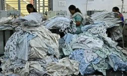 Des ouvrières confectionnent des vêtements sur des machines à coudre dans une usine de fabrication à Bengaluru, en Inde, le 25 août 2025 