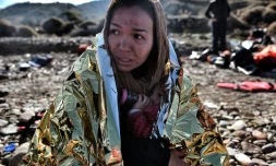 Une jeune femme arrive sur les côtes grecques à Lesbos et serre son enfant dans une couverture de survie, après avoir traversé la mer Egée, le 27 octobre 2015