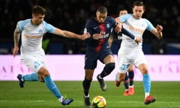 L'attaquant du PSG Kylian Mbappé entre les joueurs de l'OM Duje Caleta-Car (g) et Florian Thauvin (d) en championnat, le 17 mars 2019 au Parc des Princes 