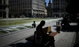 Des personnes assises à l'ombre lors d'un épisode de forte de chaleur à Lyon, le 15 août 2023