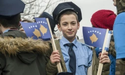 Un jeune Kosovar, déguisé en policier, brandit le drapeau de son pays, le 16 février à Pristina, à la veille des célébrations de l'indépendance.