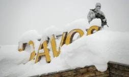 Un membre du service de sécurité, en tenue de camouflage, monte la garde sur le toit d'un hôtel à Davos (Suisse) le 22 janvier 2018