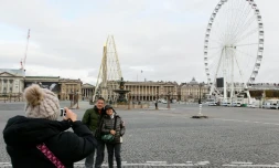 Des touristes prennent la pose devant la place de la Concorde Ă Paris le 30 novembre 2015