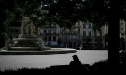 Une personne est assise à l'ombre sur la place des Jacobins, le 25 juin 2025 à Lyon