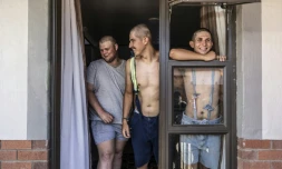 Des étudiants, Belly Sharpe (C), 18, et Eben Mans (D), 20, rient avec un ami à l'entrée de leur dortoir Vaalbos dans l'enclave afrikaner d'Orania en Afrique du Sud, le 28 janvier 2026.