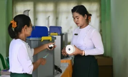 Des membres de la commission électorale de Birmanie installent des machines de vote électronique dans un bureau de vote, à Rangoun, le 24 janvier 2026