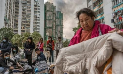 Des habitants trient des vĂȘtements qui leur ont Ă©tĂ© donnĂ©s aprĂšs qu'un important incendie a ravagĂ© plusieurs immeubles d'appartements du complexe rĂ©sidentiel Wang Fuk Court Ă Hong Kong, le 27 novembre 2025