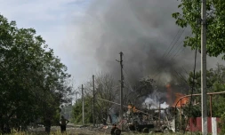 Des habitants devant une maison en feu après une attaque de missile à Myrnohrad, dans la région de Donetsk, le 21 août 2024 en Ukraine