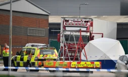 Des policiers britanniques se tiennent prÚs d'un camion charnier dans lequel 39 migrants vietnamiens ont trouvé la mort, le 23 octobre 2019 à Grays (Royaume-Uni)