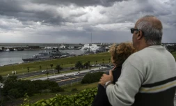 Un couple regarde un bateau militaire à son retour dans le port de Mar del Plata après ses recherches du sous-marin argentin San Juan, le 20 novembre 2017   